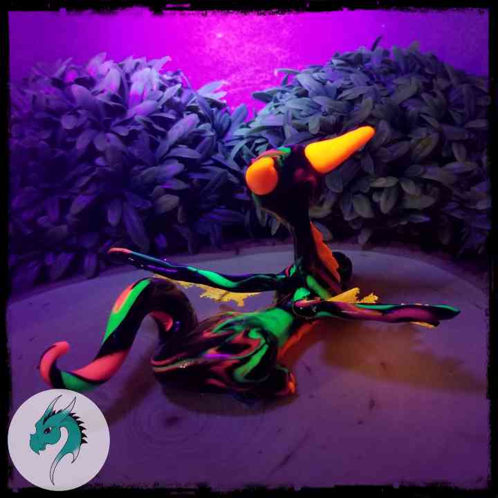Back view of a clay dragon reacting to blacklight