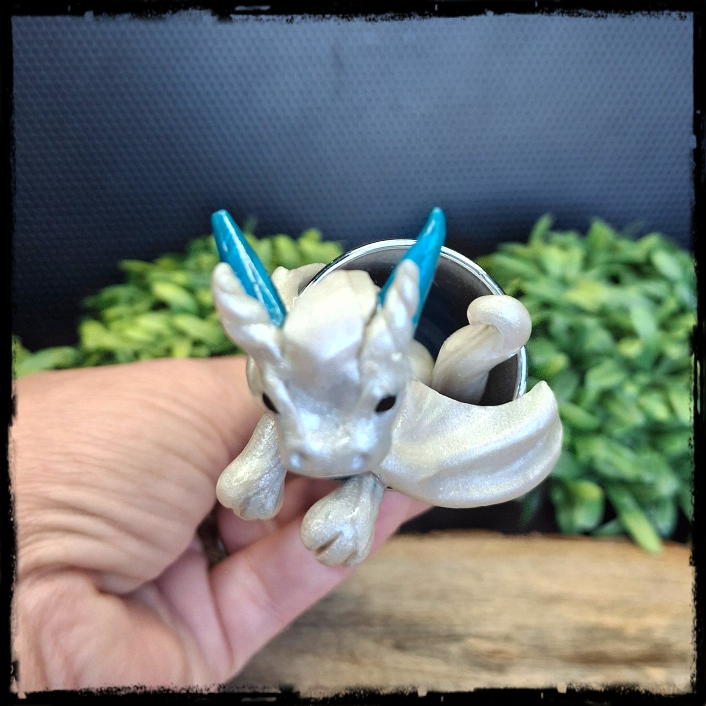 Top view of a white clay dragon inside a tall shot glass
