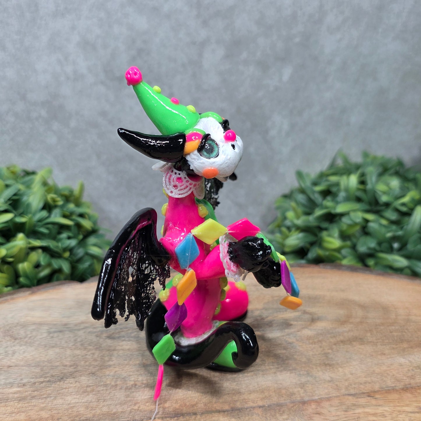 A clown dragon on wood surface with greenery