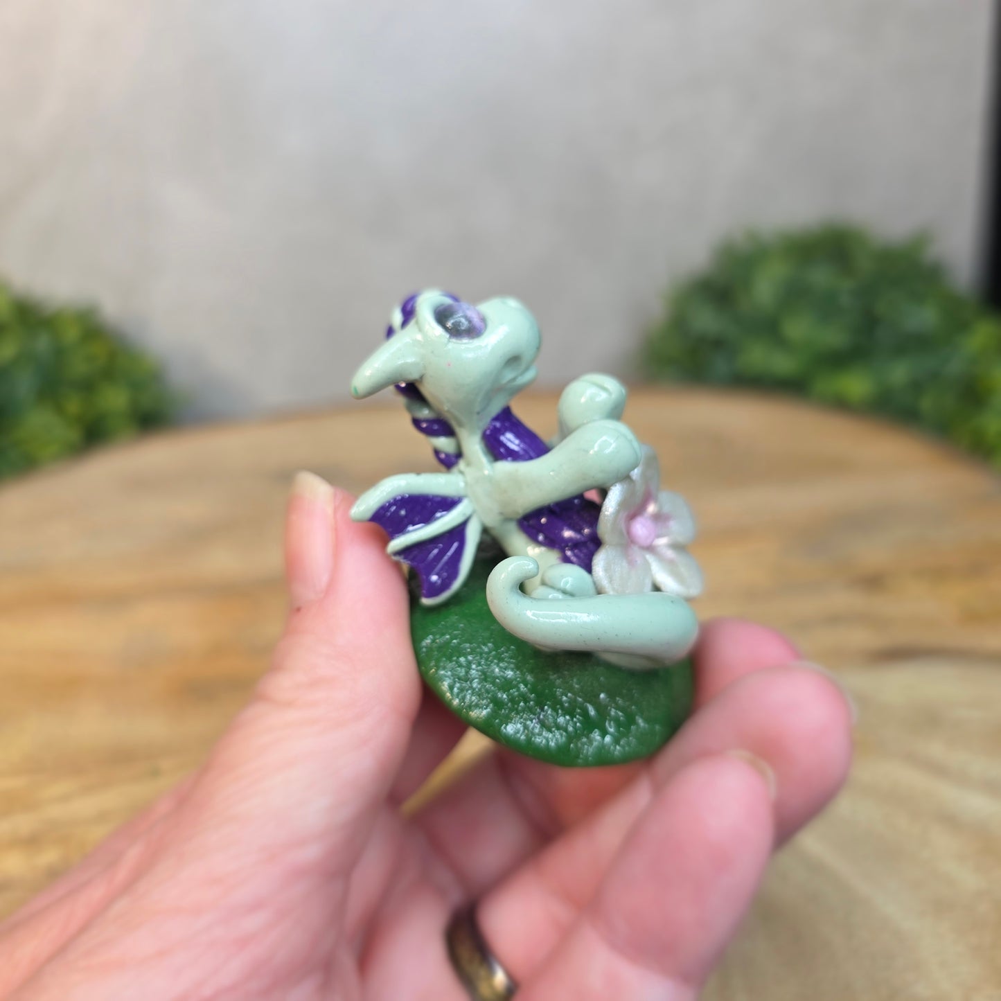 Hand holding a small clay dragon