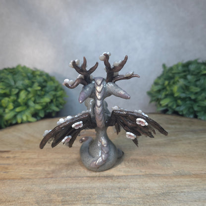 A gray colored dragon with cherry blossom accents