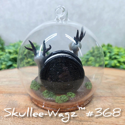 Back view of two Skullee-Wagz with cookies in a  glass dome set on a wood surface with greenery. Text reads Skullee-Wagz #368