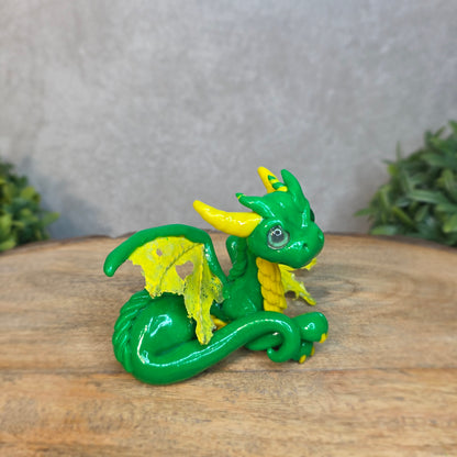 A green and yellow dragon against a blurred wood surface