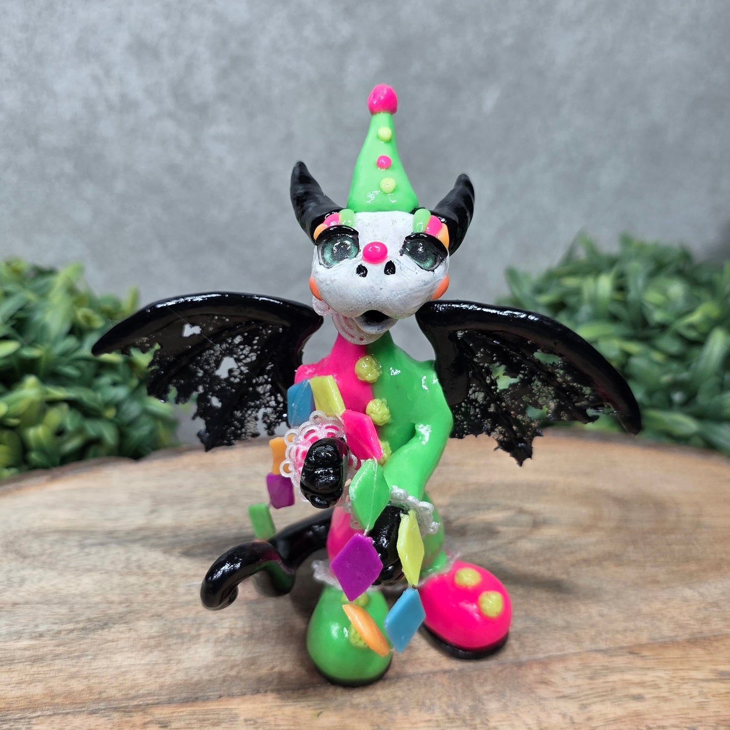 A clown dragon on wood surface with greenery