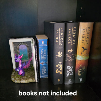 Book nook with fairy dragon on bookshelf with text that says books not included