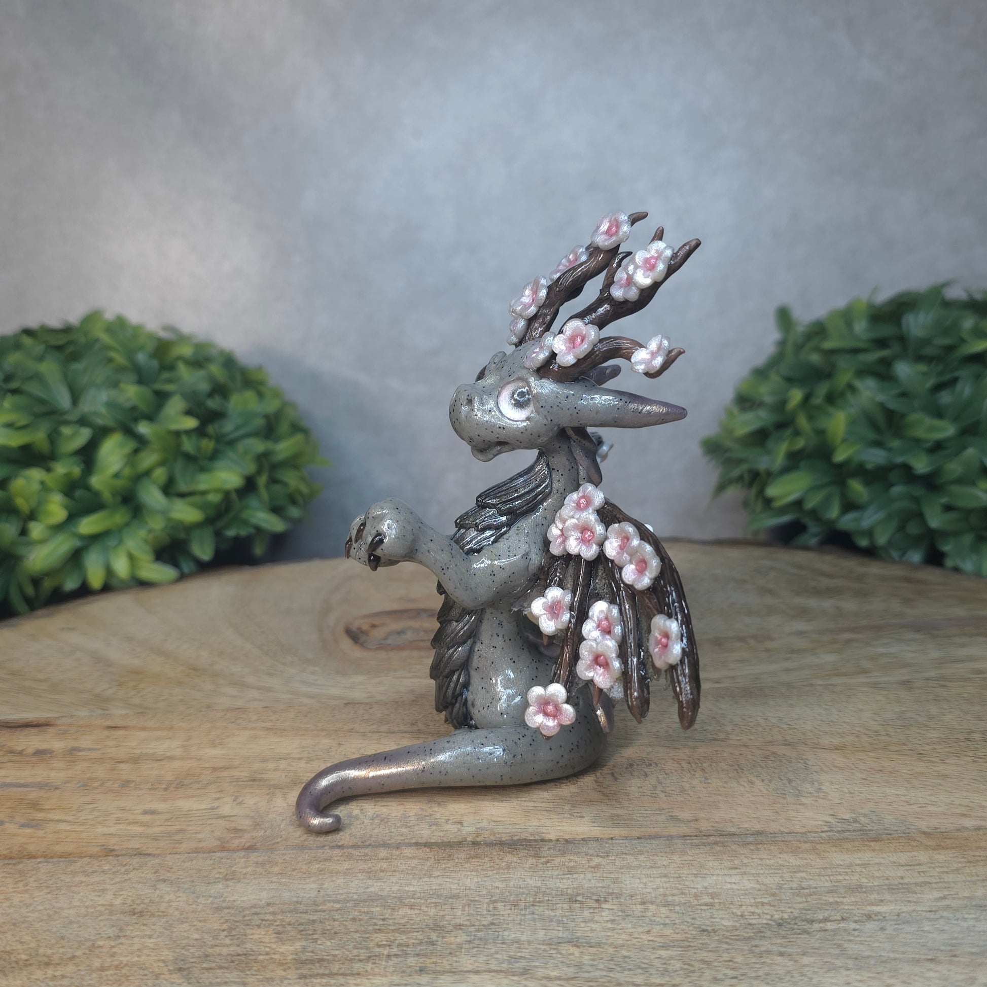 A gray colored dragon with cherry blossom accents