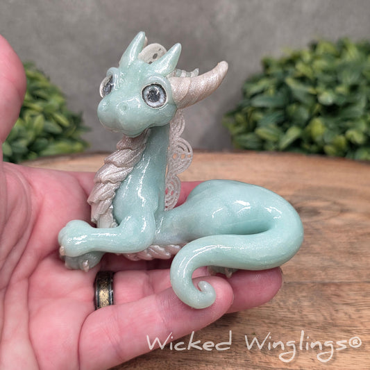 A hand holding a dragon sculpture