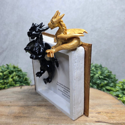 Book nook with dragons on a wood surface with greenery