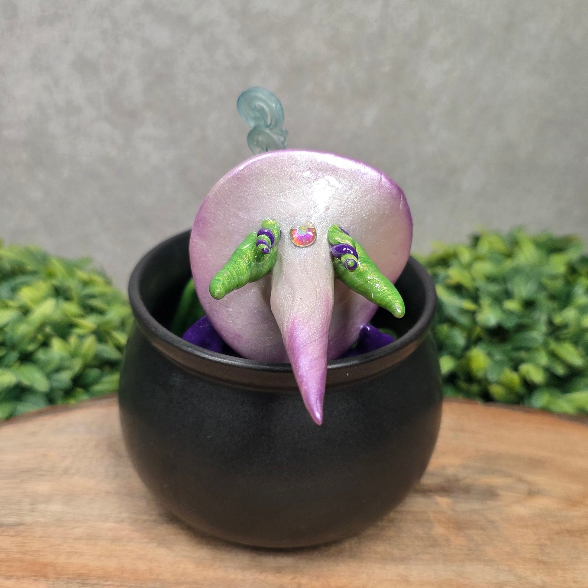 A pair of clay dragons in a cauldron with greenery