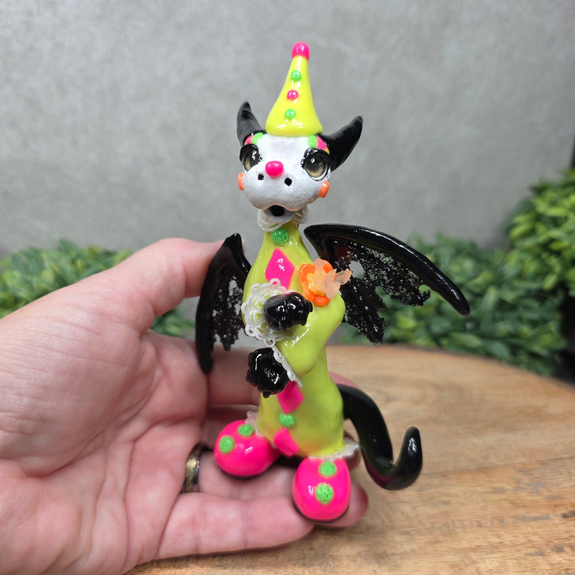 A clown dragon on wood surface with greenery