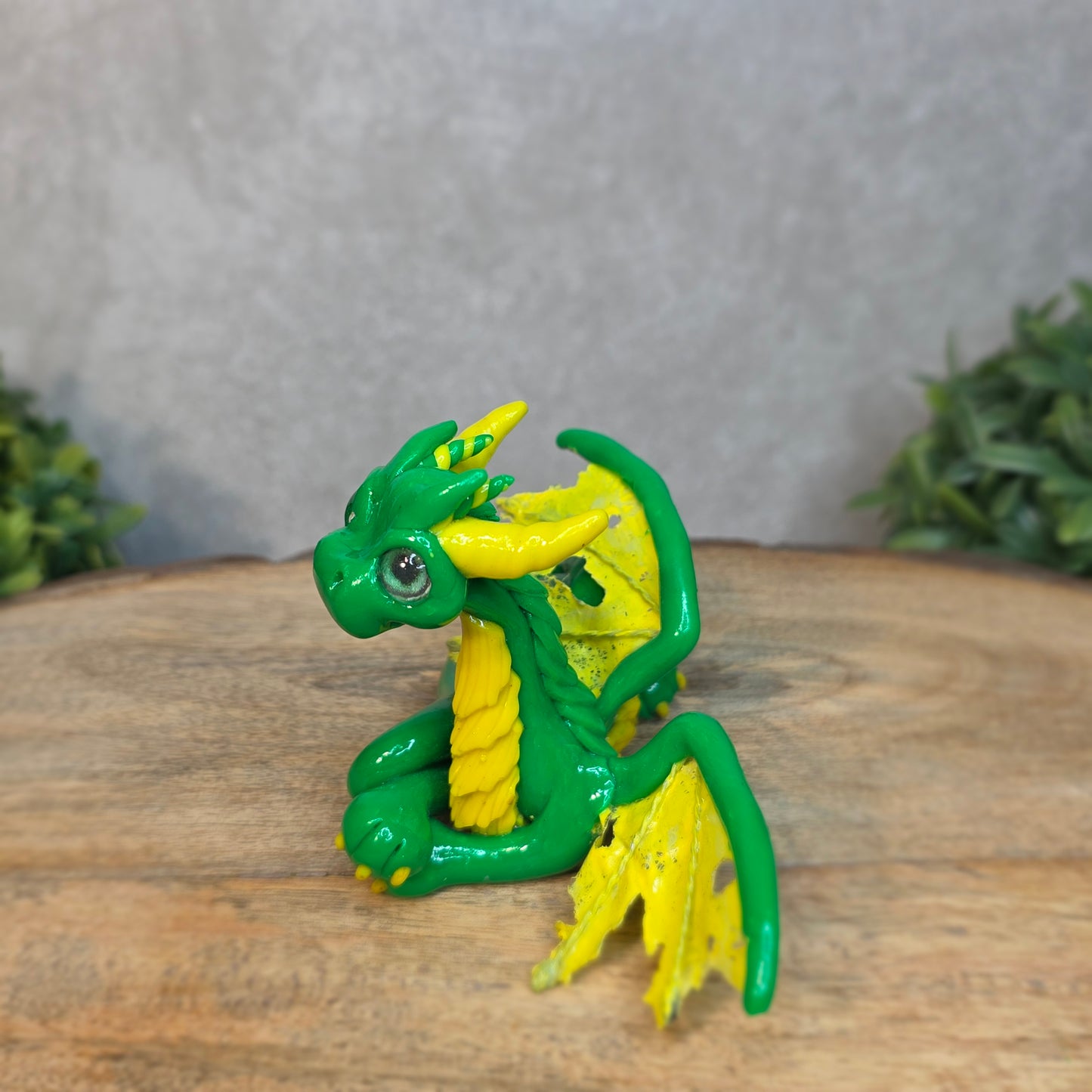 A green and yellow dragon against a blurred wood surface