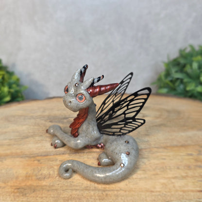 Fairy dragon with butterfly wings on a wooden surface