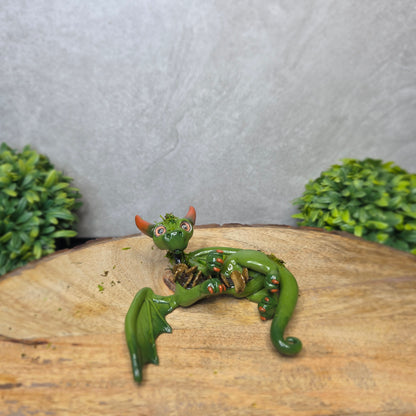 A green clay dragon against a blurred background