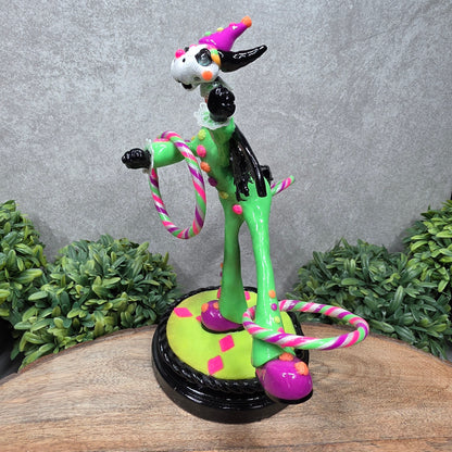 A clown dragon with hoola hoops on a wood surface with greenery