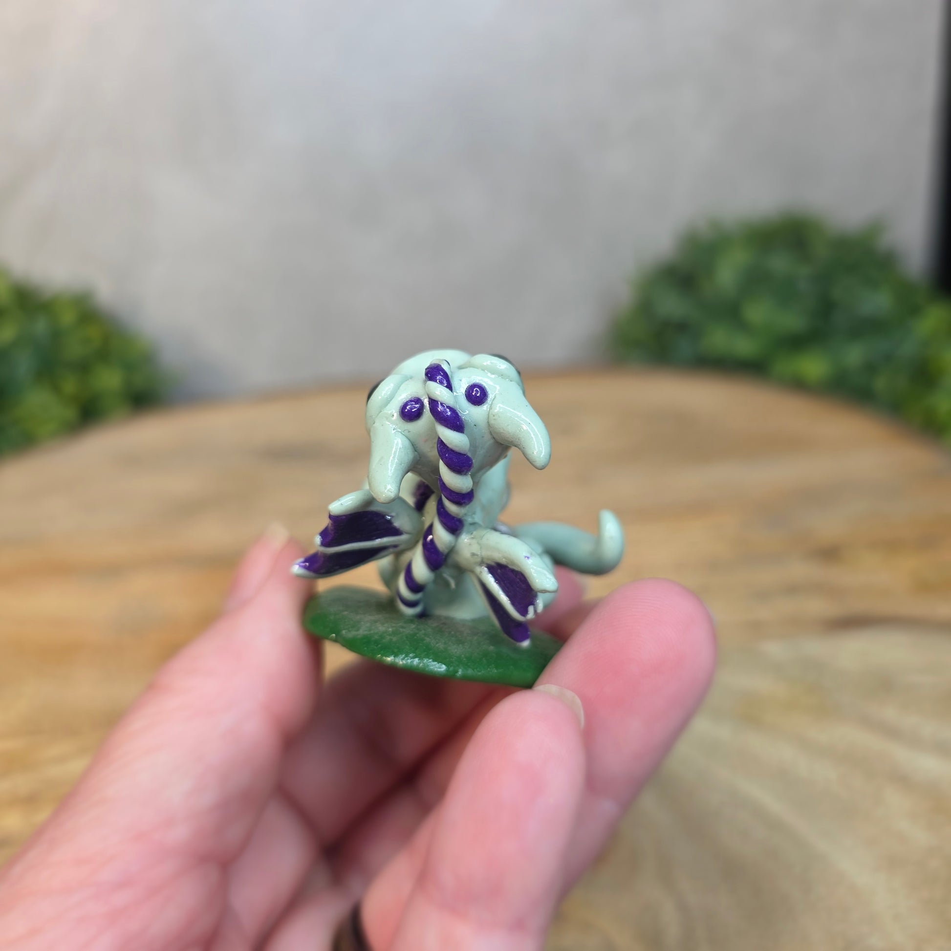 Hand holding a small clay dragon
