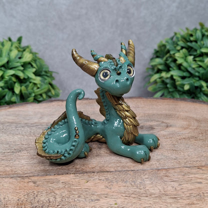  A clay dragon against a wood background with greenery