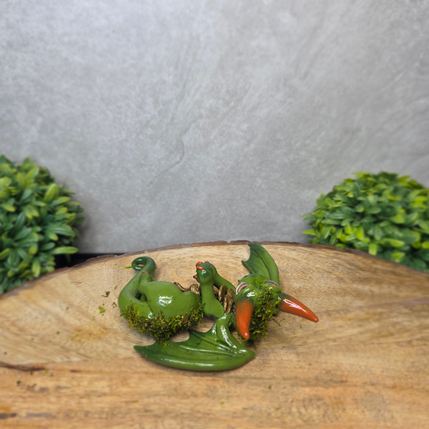 A green clay dragon against a blurred background