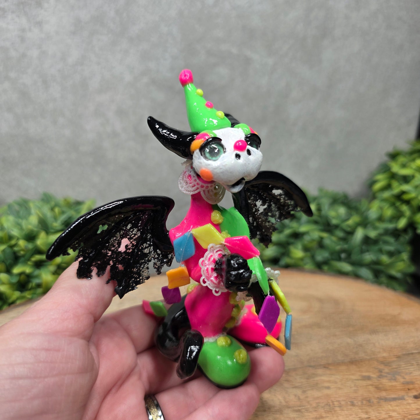 A clown dragon on wood surface with greenery