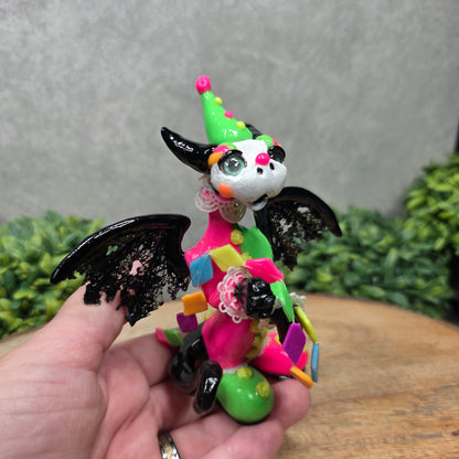 A clown dragon on wood surface with greenery