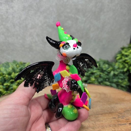A clown dragon on wood surface with greenery