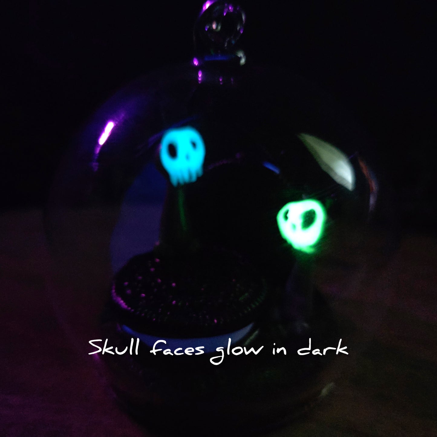 Two Skullee-Wagz in dark in a  glass dome with glowing faces. Text reads Skull faces glow in dark