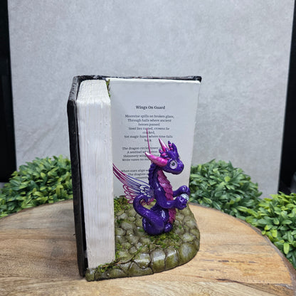 Book nook with fairy dragon on a wood surface with greenery