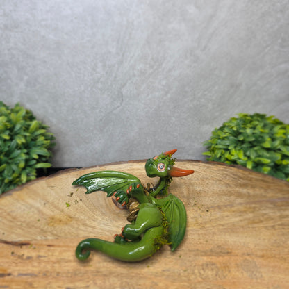 A green clay dragon against a blurred background