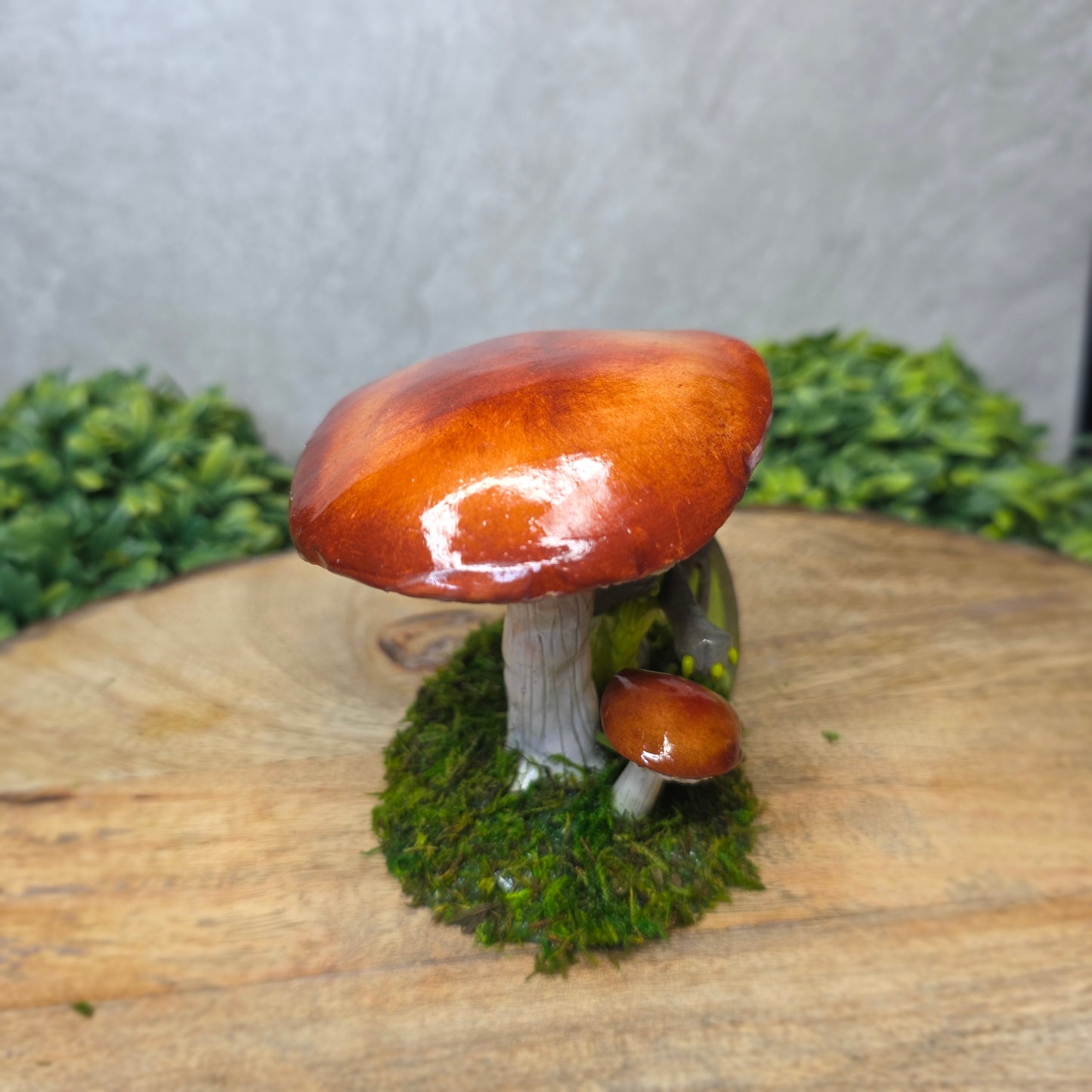 Decorative mushroom with a brown cap and green base on a wooden surface.