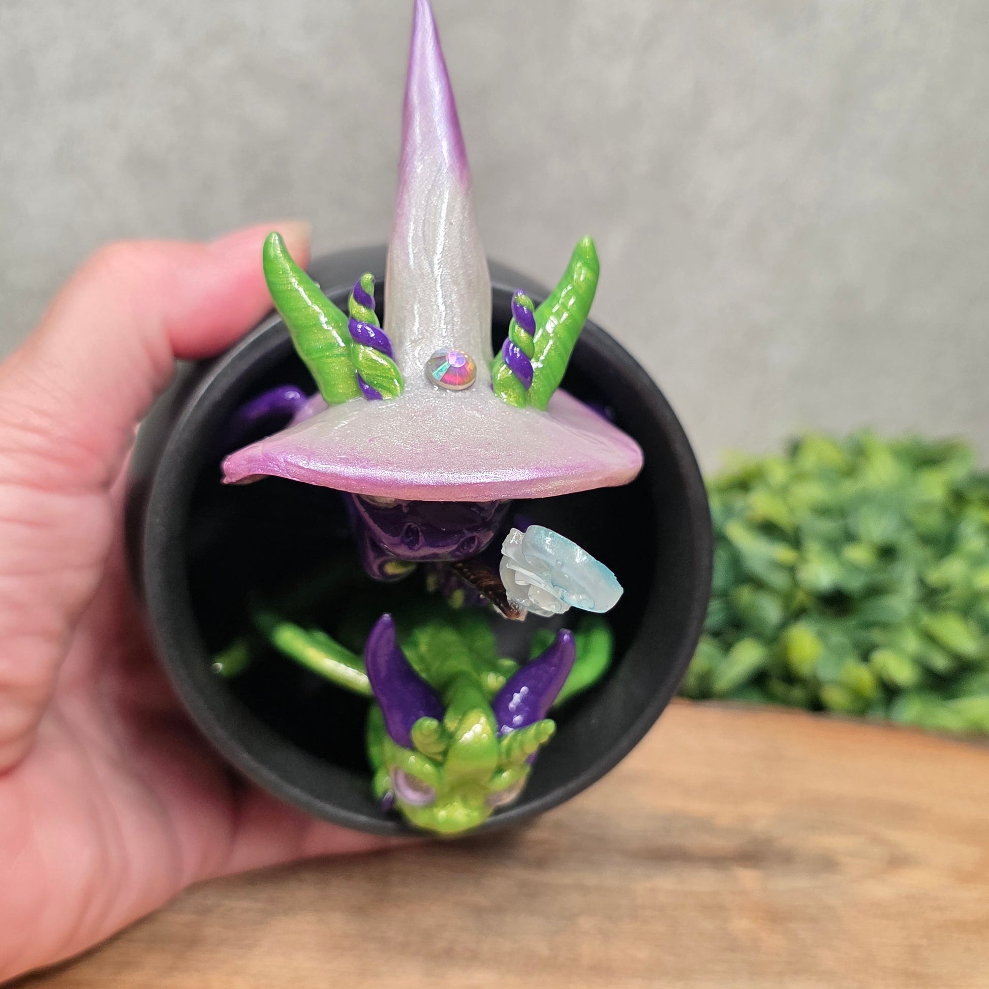 A pair of clay dragons in a cauldron with greenery