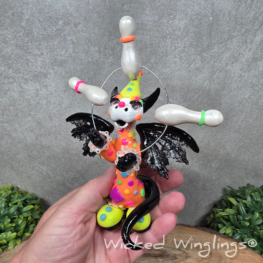 A clown dragon juggling on a wood surface with greenery