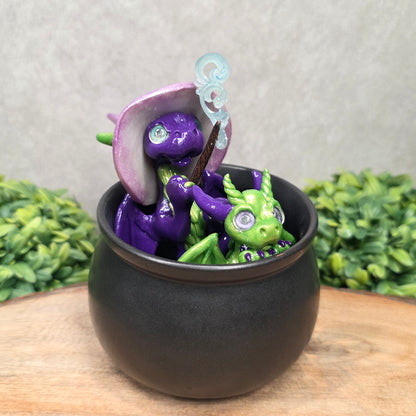 A pair of clay dragons in a cauldron with greenery
