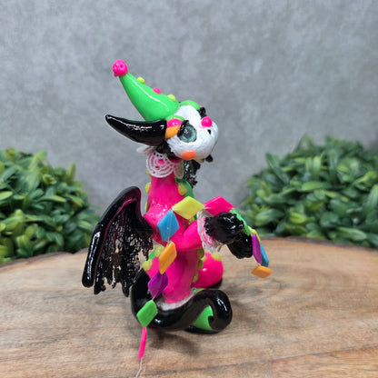 A clown dragon on wood surface with greenery