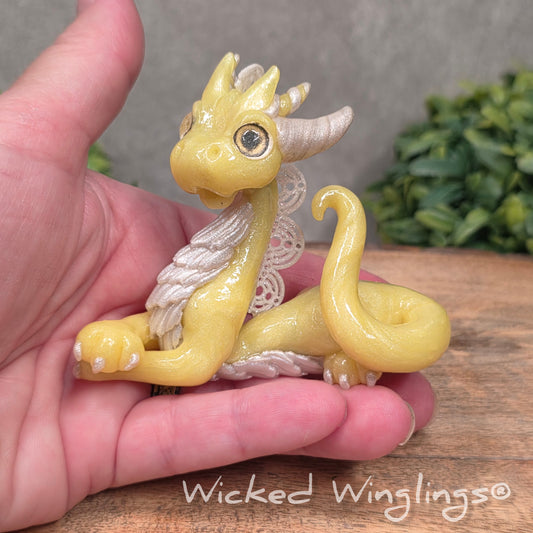 A hand holding a dragon sculpture