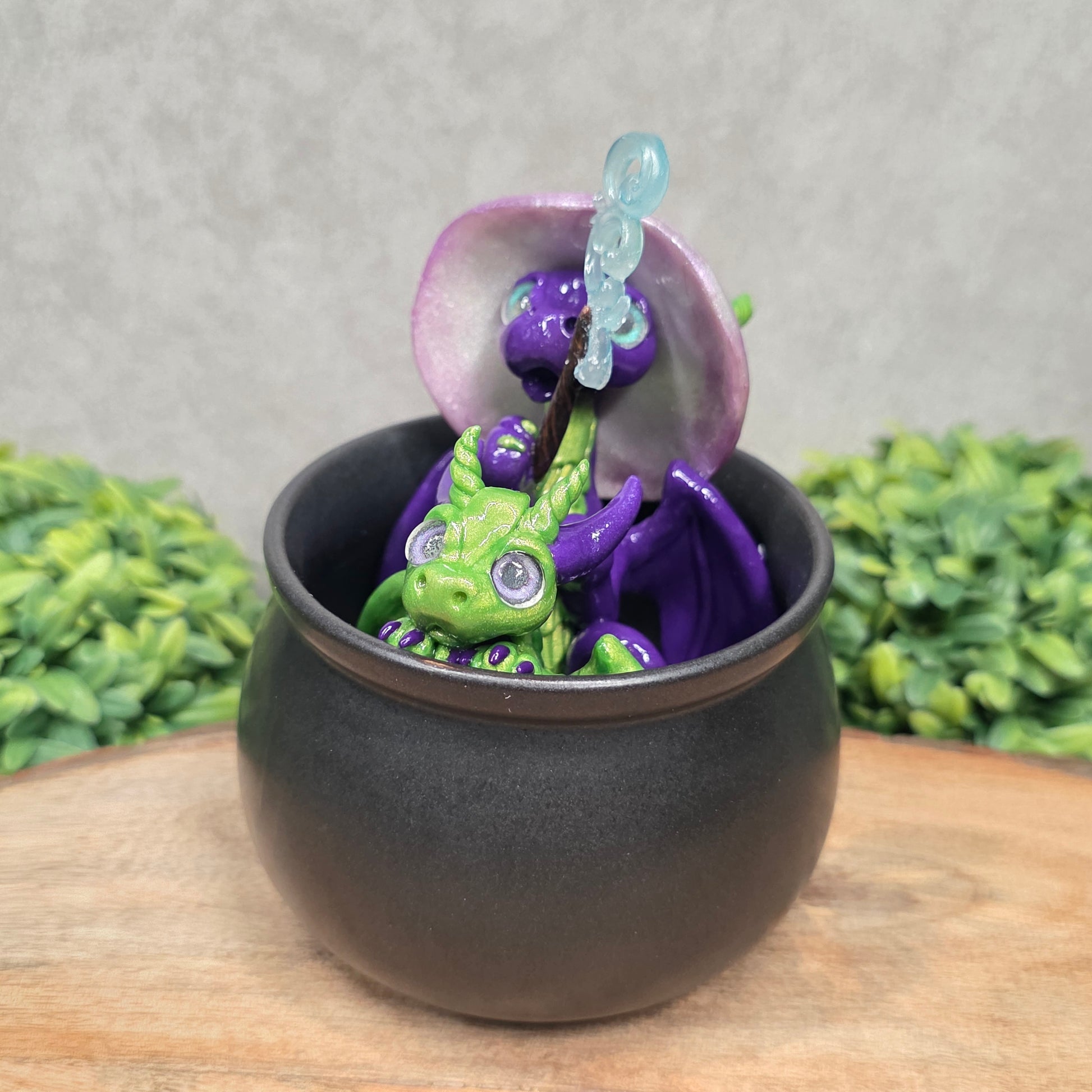 A pair of clay dragons in a cauldron with greenery